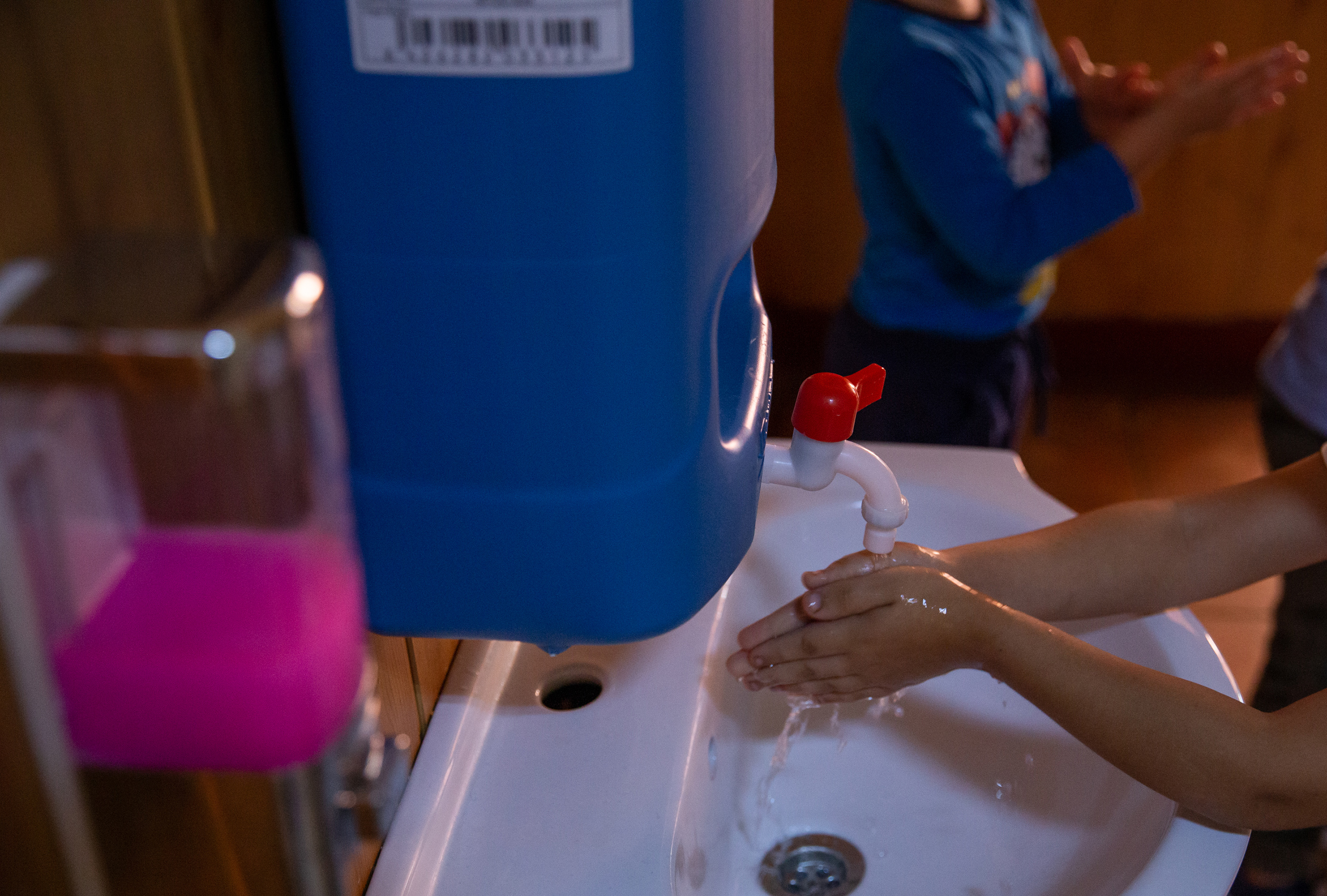 O fetiță se spală pe mâini